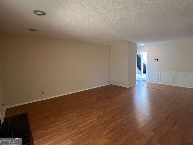 unfurnished room with dark hardwood / wood-style floors and a textured ceiling