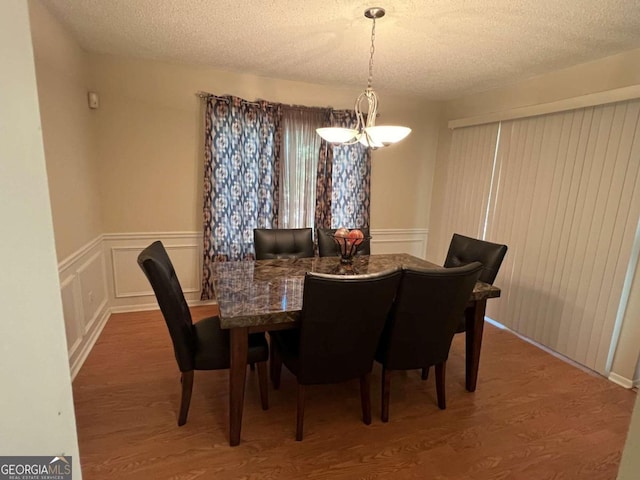 dining area featuring a textured ceiling and hardwood / wood-style flooring