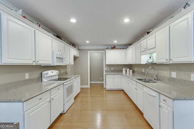 kitchen featuring white appliances, white cabinetry, and light wood-type flooring