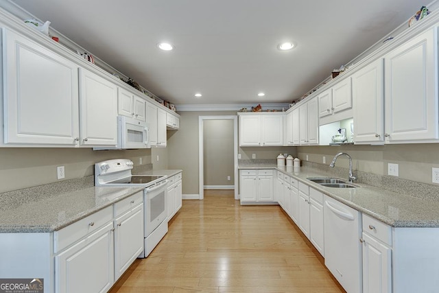 kitchen with white cabinets, a sink, recessed lighting, white appliances, and ornamental molding