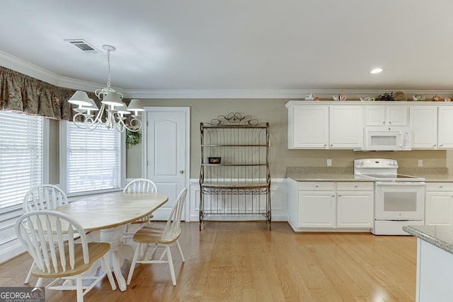 kitchen with white cabinets, white appliances, a notable chandelier, and ornamental molding
