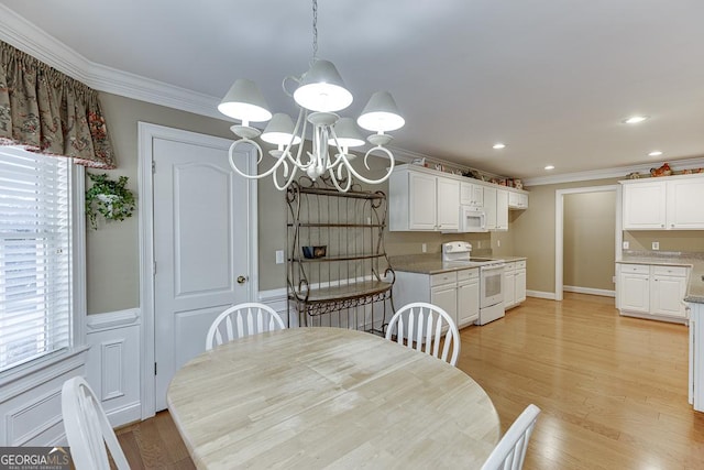 dining space with light wood finished floors, an inviting chandelier, recessed lighting, and ornamental molding