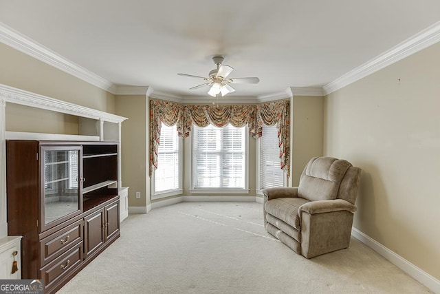 living area with light colored carpet, ceiling fan, baseboards, and ornamental molding
