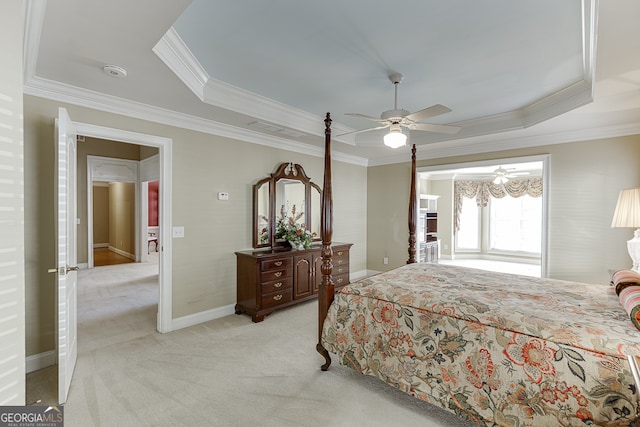 carpeted bedroom featuring ceiling fan, a tray ceiling, and ornamental molding