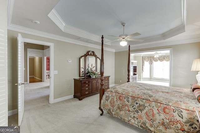 bedroom featuring a raised ceiling, crown molding, and light colored carpet