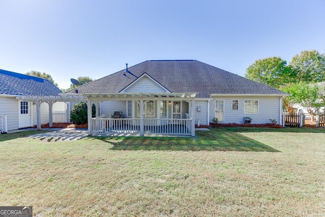 rear view of house featuring a pergola, a patio area, fence, a yard, and roof with shingles