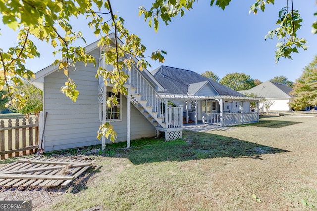 rear view of house featuring a yard