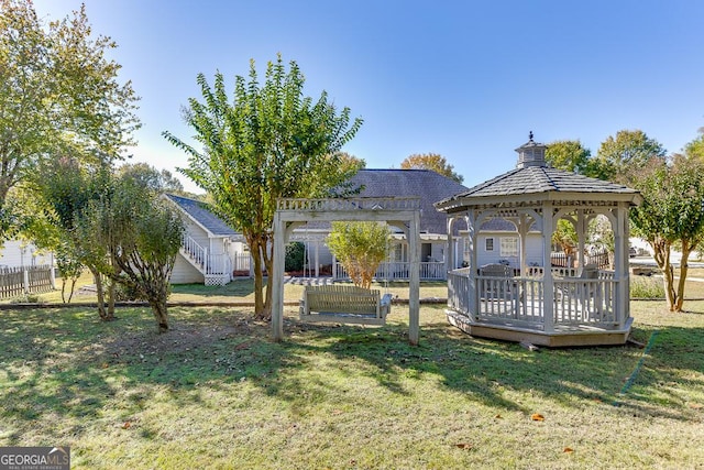 view of yard featuring a wooden deck, a gazebo, and fence