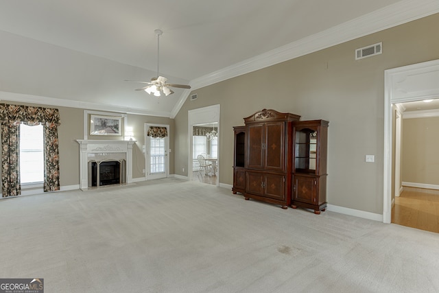 unfurnished living room featuring ornamental molding, lofted ceiling, light carpet, and ceiling fan