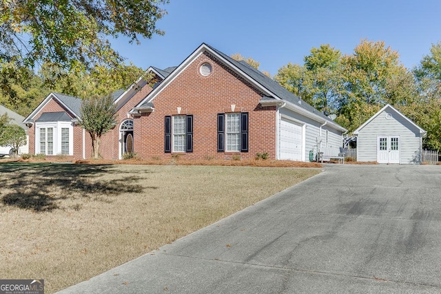 single story home featuring brick siding, an attached garage, a front lawn, and driveway