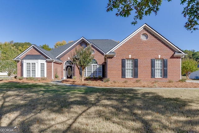 ranch-style house with a front lawn and brick siding