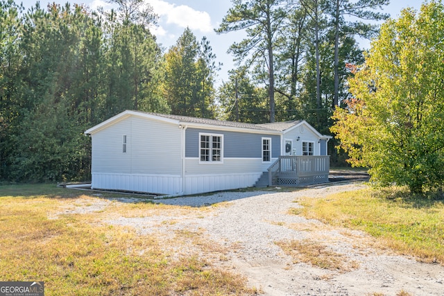 manufactured / mobile home with a deck and a front lawn