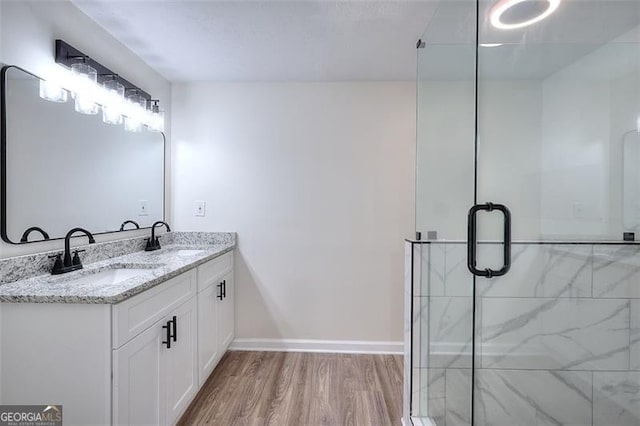 bathroom featuring a shower with door, vanity, and wood-type flooring