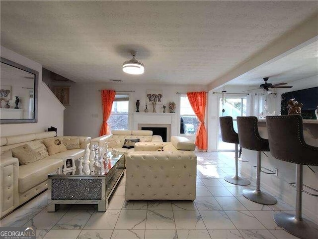 living room featuring a textured ceiling and ceiling fan