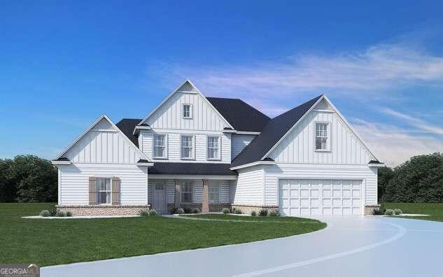 view of front of property with an attached garage, driveway, board and batten siding, and a front yard