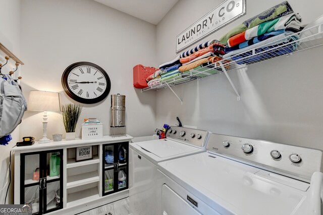 clothes washing area with washing machine and dryer