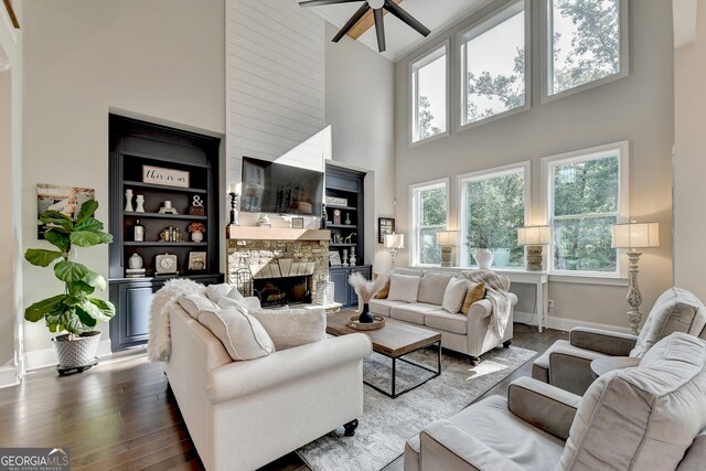 living room featuring a fireplace, hardwood / wood-style flooring, high vaulted ceiling, and ceiling fan