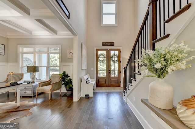 foyer with french doors, coffered ceiling, beam ceiling, ornamental molding, and dark hardwood / wood-style floors