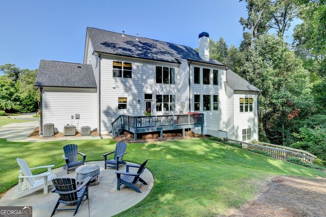 back of house with a patio, an outdoor fire pit, a deck, a lawn, and central AC unit