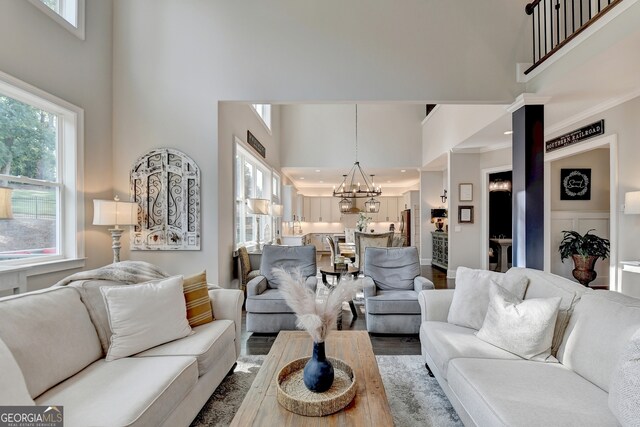 living room featuring wood-type flooring, a high ceiling, and a wealth of natural light