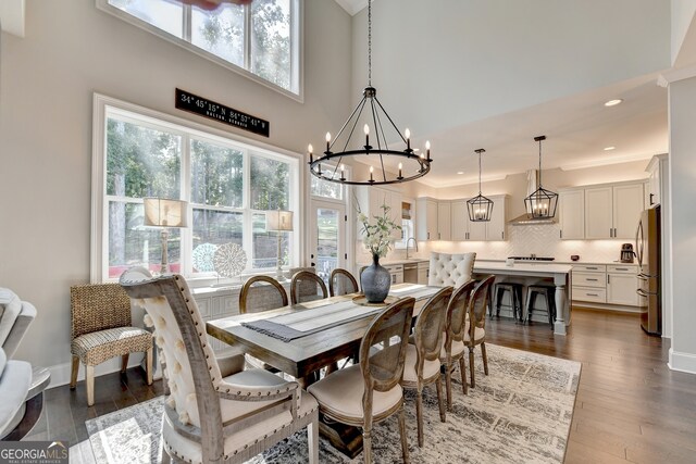 dining space featuring crown molding, a towering ceiling, a wealth of natural light, and dark hardwood / wood-style floors