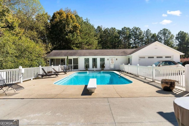 view of pool featuring a diving board and a patio area