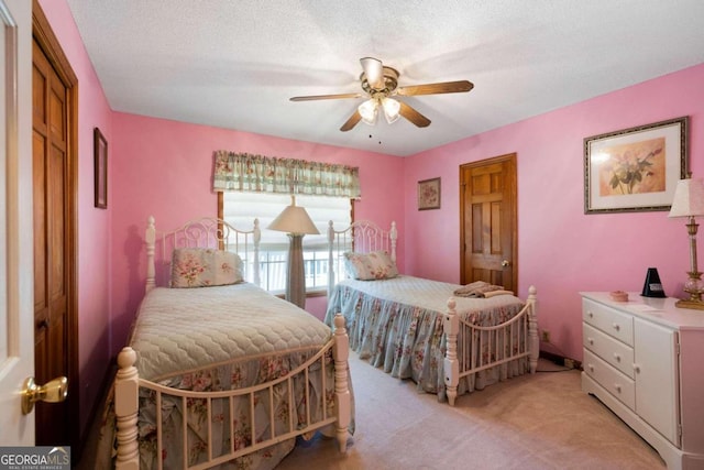 carpeted bedroom featuring a textured ceiling and ceiling fan