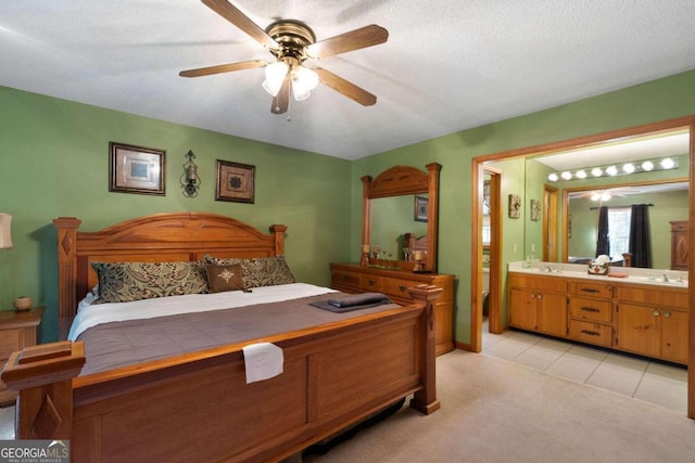 carpeted bedroom featuring ensuite bathroom, a textured ceiling, and ceiling fan