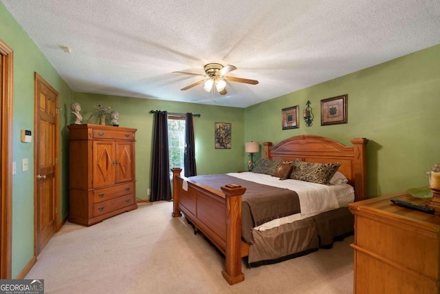 carpeted bedroom with ceiling fan and a textured ceiling