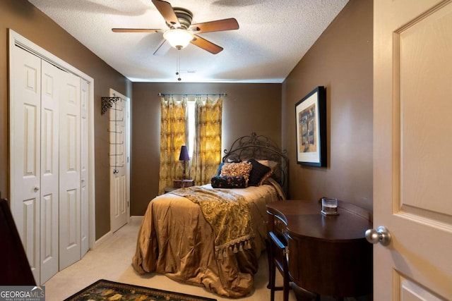 carpeted bedroom featuring a textured ceiling, a closet, and ceiling fan