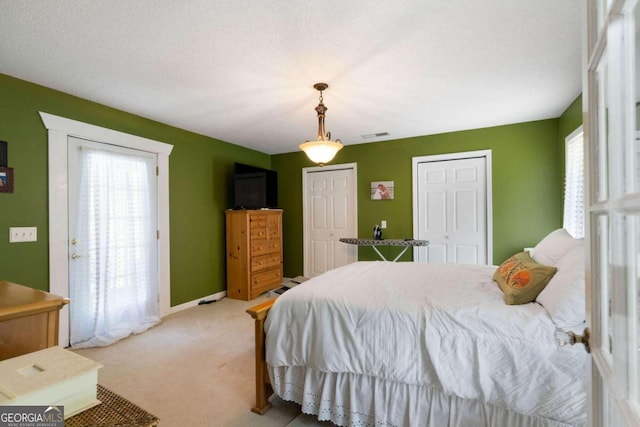 carpeted bedroom with multiple windows and a textured ceiling