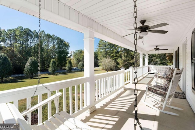 wooden deck with a yard, ceiling fan, and a porch