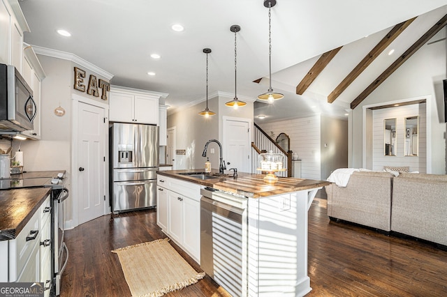 kitchen featuring vaulted ceiling with beams, stainless steel appliances, sink, and an island with sink