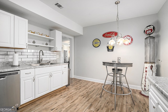 kitchen featuring white cabinetry, sink, stainless steel dishwasher, and hanging light fixtures