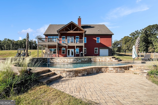 back of property with a patio, a balcony, and a garage