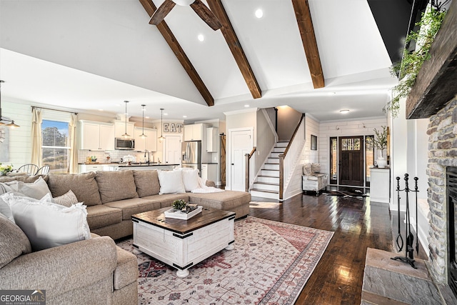 living room with sink, vaulted ceiling with beams, a fireplace, and dark hardwood / wood-style flooring