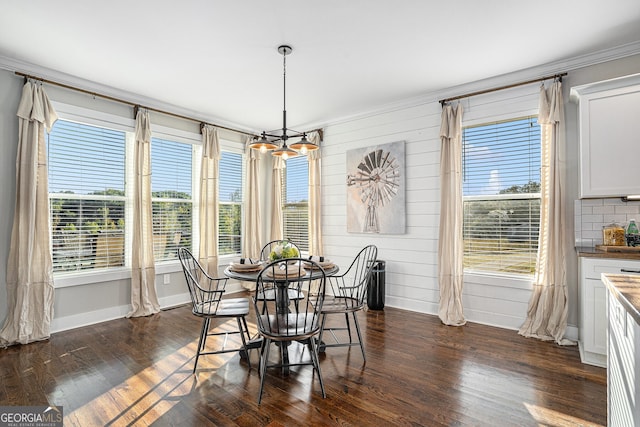 dining room featuring crown molding, wood walls, and dark hardwood / wood-style flooring