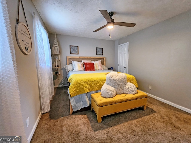 bedroom featuring ceiling fan, a textured ceiling, and dark carpet