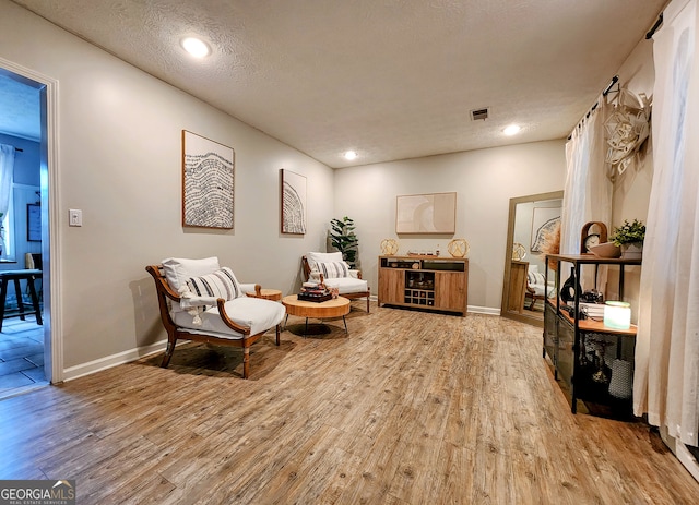 living area featuring hardwood / wood-style floors and a textured ceiling