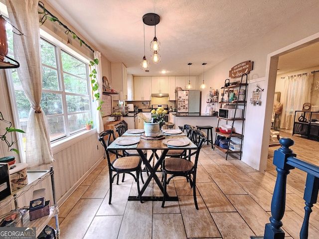 dining space with a wealth of natural light and a textured ceiling