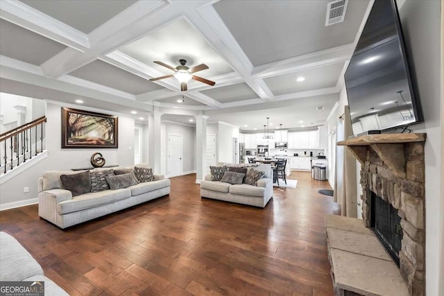 living room with dark hardwood / wood-style floors, beam ceiling, coffered ceiling, and ornate columns