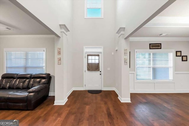 entryway with ornamental molding and dark wood-type flooring