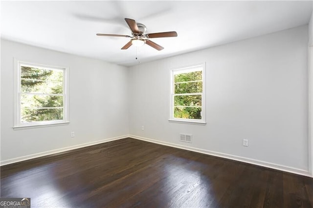 504 Milligan Dr, Stone Mountain, GA 30083 - spare room with dark wood-style flooring, a ceiling fan, and baseboards