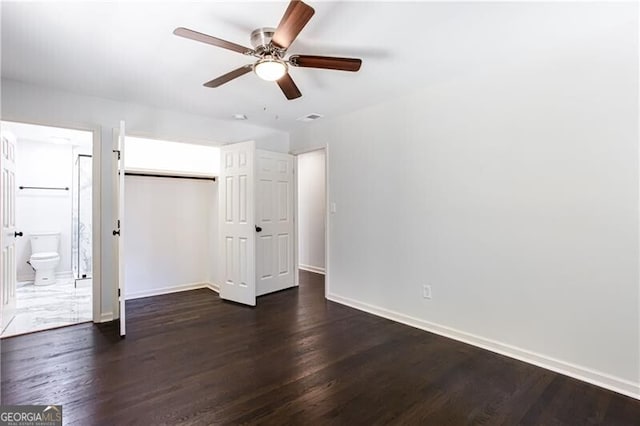 504 Milligan Dr, Stone Mountain, GA 30083 - unfurnished bedroom with baseboards, a closet, dark wood-type flooring, a ceiling fan, and ensuite bathroom