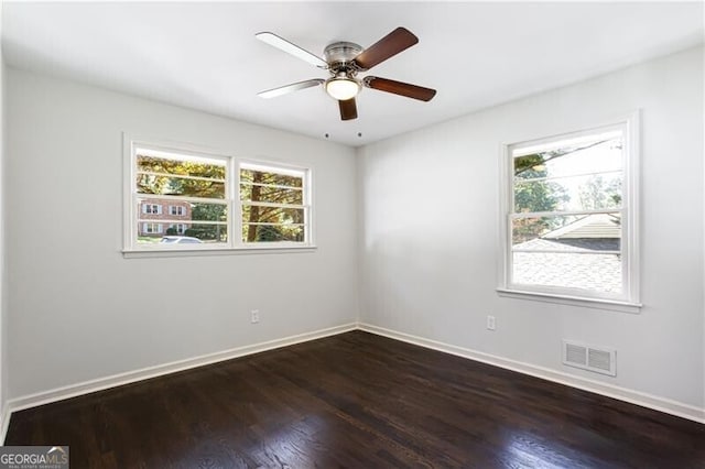 504 Milligan Dr, Stone Mountain, GA 30083 - empty room featuring healthy amount of natural light, dark wood-style floors, and baseboards