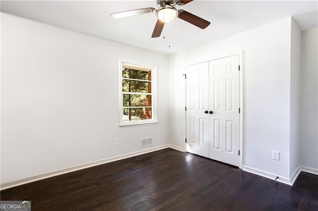 504 Milligan Dr, Stone Mountain, GA 30083 - unfurnished bedroom featuring dark wood-style floors, baseboards, a closet, and ceiling fan