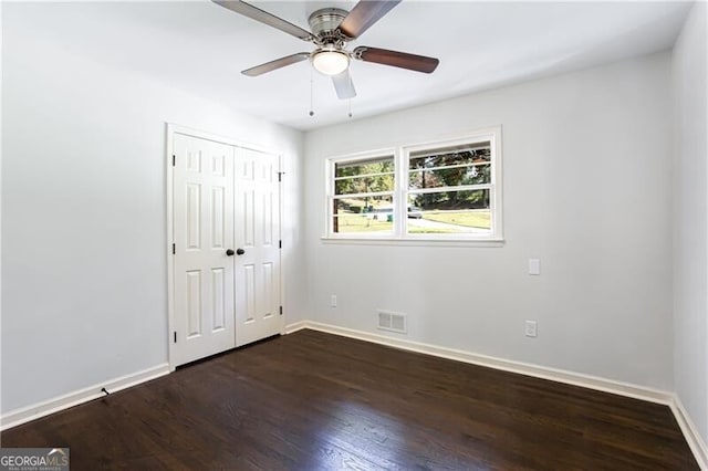 504 Milligan Dr, Stone Mountain, GA 30083 - unfurnished bedroom featuring baseboards, dark wood-style flooring, and a closet