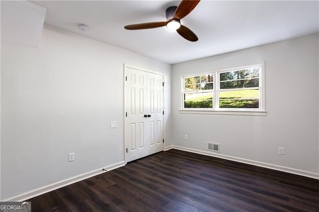 504 Milligan Dr, Stone Mountain, GA 30083 - unfurnished bedroom featuring dark wood-style flooring, baseboards, a closet, and ceiling fan