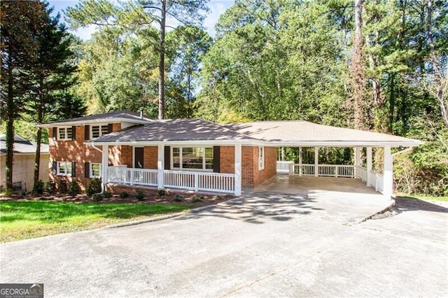 504 Milligan Dr, Stone Mountain, GA 30083 - view of front of home with asphalt driveway, a porch, brick siding, and a carport