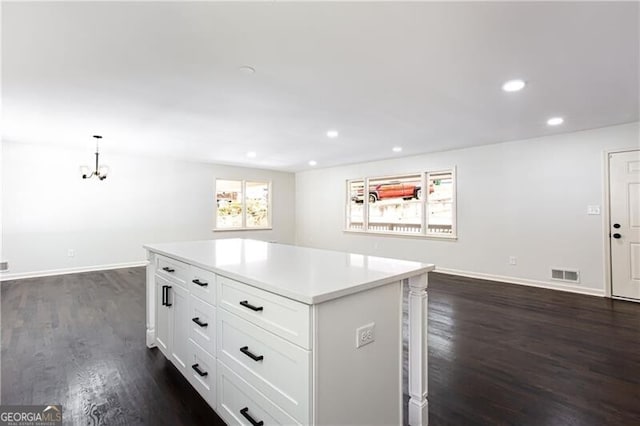 504 Milligan Dr, Stone Mountain, GA 30083 - kitchen with dark wood-style flooring, a kitchen island, light countertops, white cabinets, and recessed lighting